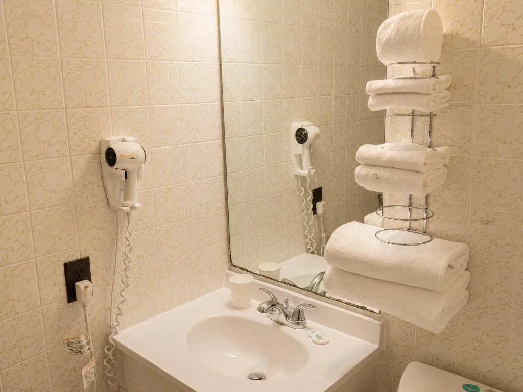 Clean guest bathroom vanity with mirror, sink and fresh towels