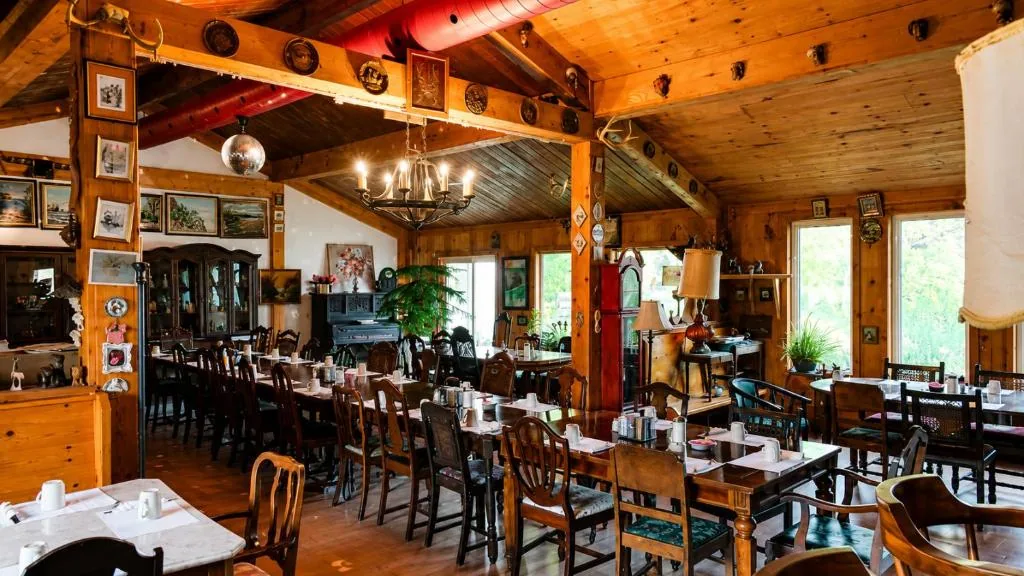 Top Notch restaurant interior featuring wood walls, dining tables and framed local artwork