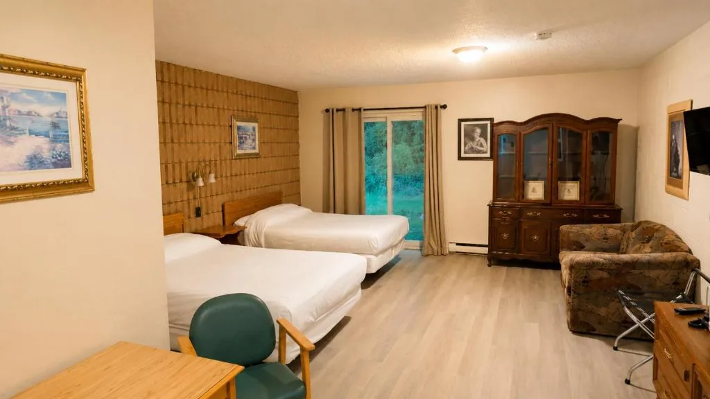 Large motel room with two beds, sofa, television and dining table