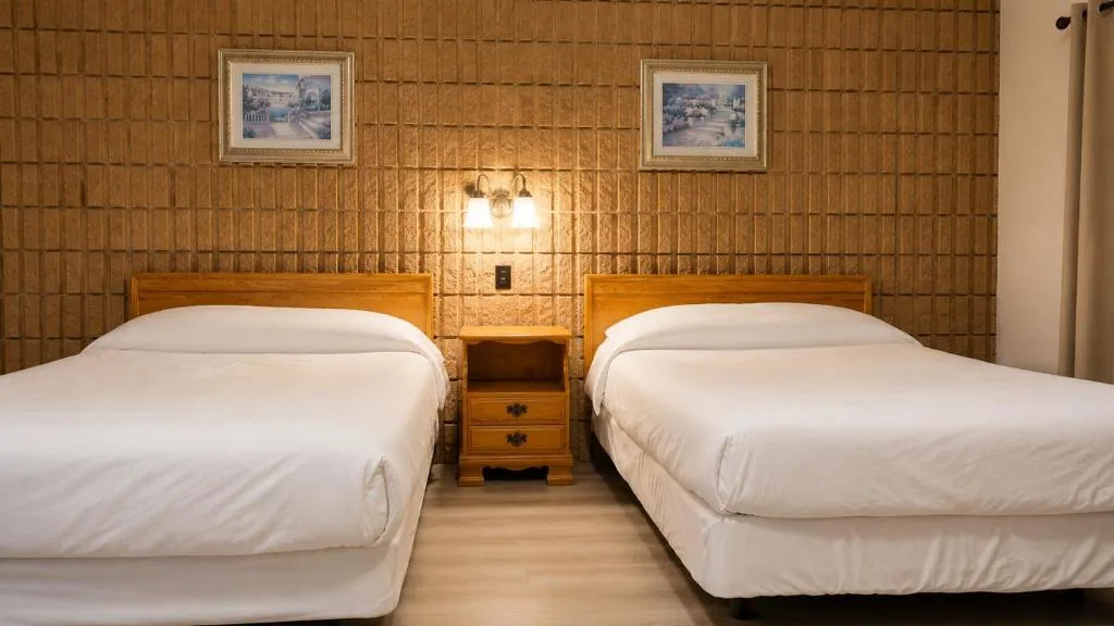 Top Notch motel room with two neatly made beds and a small table